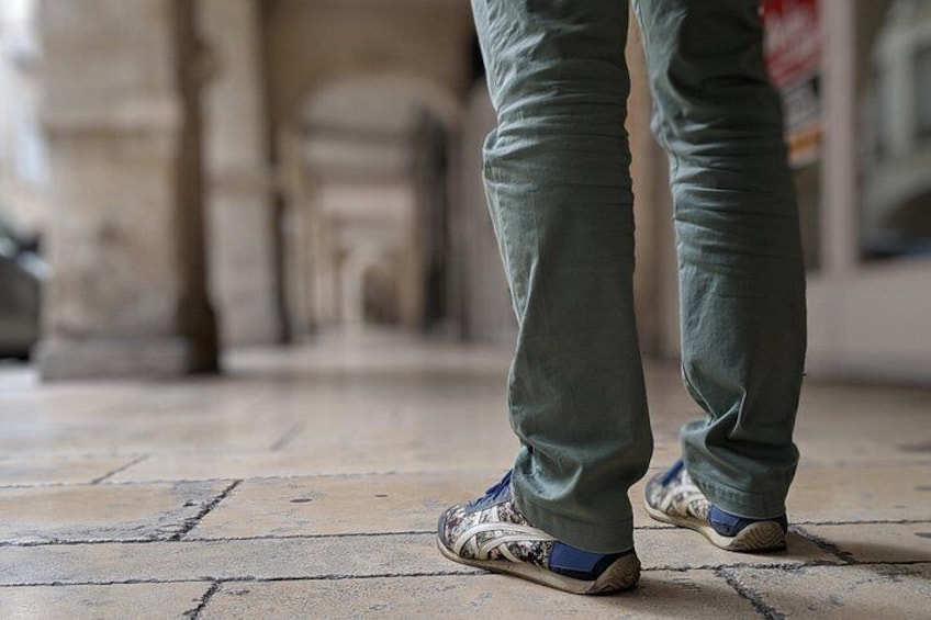 Füße in Turnschuhen auf einem Fliesenboden. 2