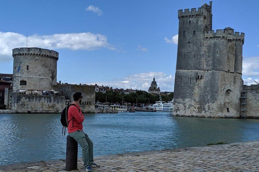 A person standing by a historic castle with a river in the foreground. 4