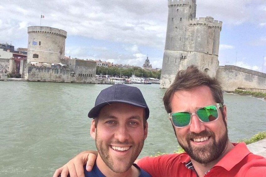 Two people in front of a historic castle by a river. 5