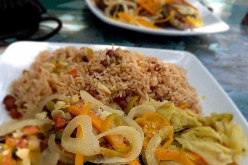 A plate of fried rice with vegetables and a side of sliced onions. 5