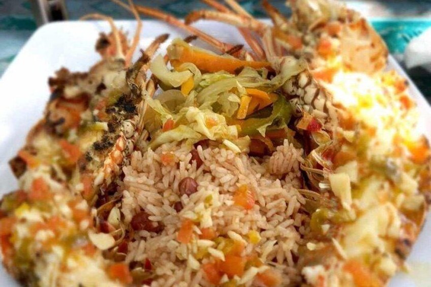 A plate of rice with vegetables and a lobster tail. 4