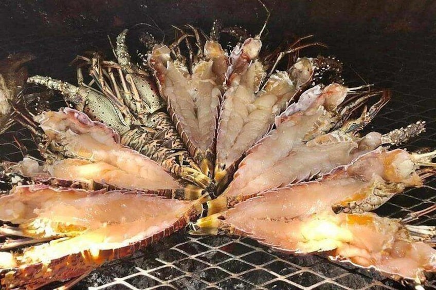 A grilled seafood dish with shrimp and possibly lobster, served on a grill. 3