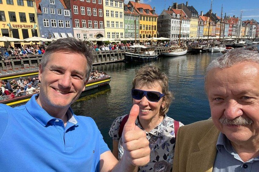 En kanal med båtar, färgglada byggnader och människor. 2