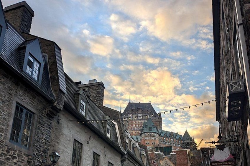 A historic town with stone buildings, a prominent castle, and a string of lights. 2