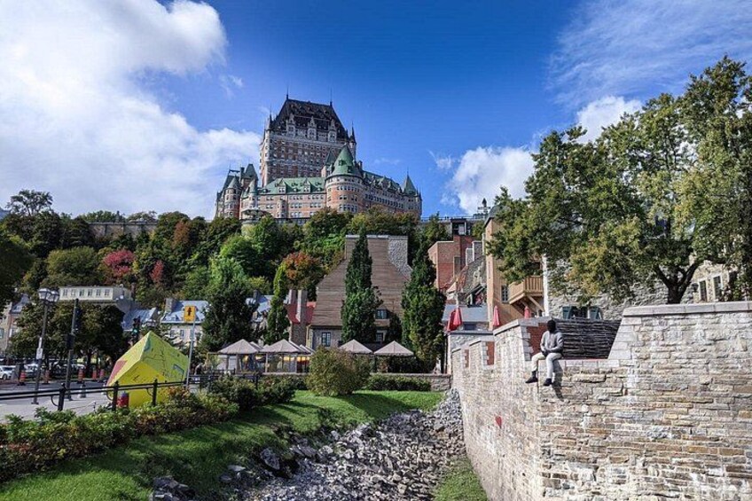 A historic castle on a hill, a stone wall, and a small yellow tent. 3