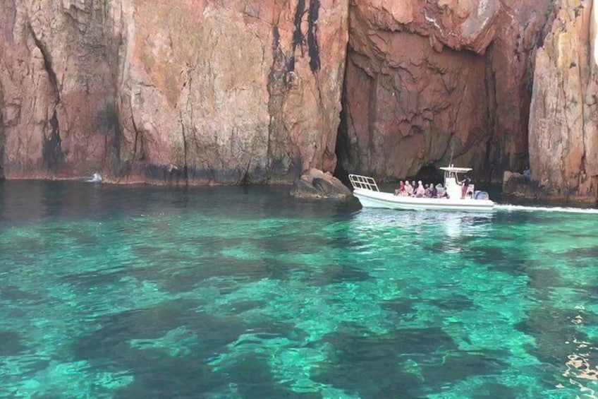 A boat with passengers near a rocky cliff. 5
