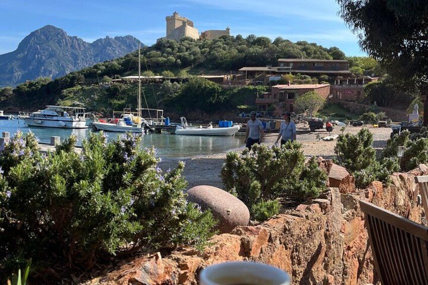 A coastal town with boats docked, rocky terrain, and a castle on a hill. 2