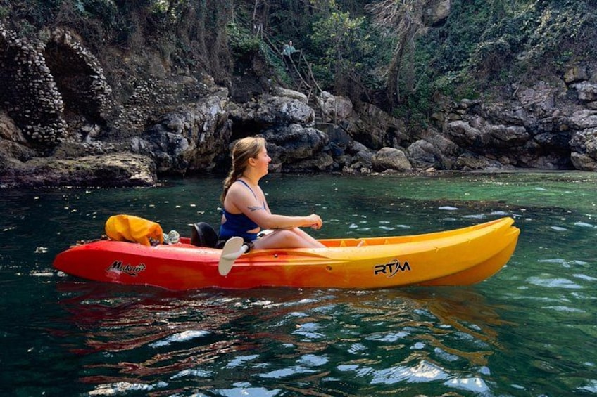A person kayaking on a river surrounded by rocky cliffs. 3