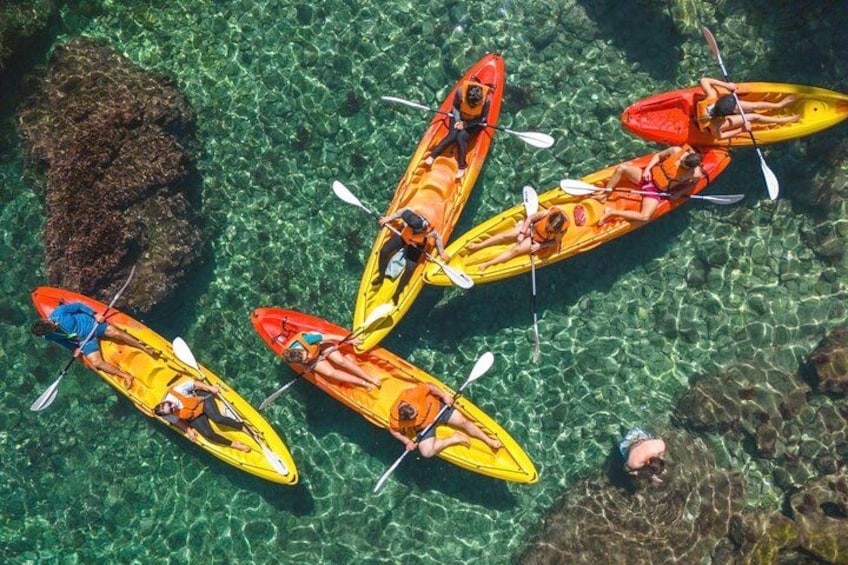 Kayakers in bright yellow and orange kayaks on clear water. 4