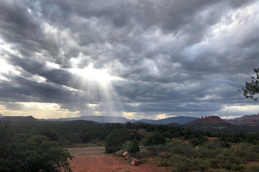 A landscape with a dirt path, dense shrubbery, and distant mountains under a cloudy sky. 3