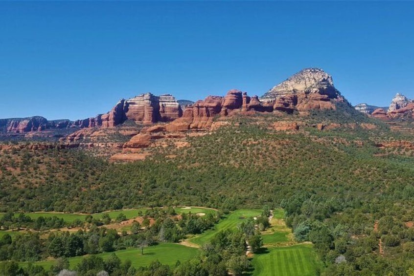 Paesaggio montuoso con formazioni rocciose rosse e vegetazione verde. 1