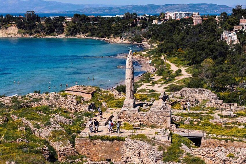 Ruinas antiguas, un obelisco alto y un paisaje costero con edificios al fondo. 3