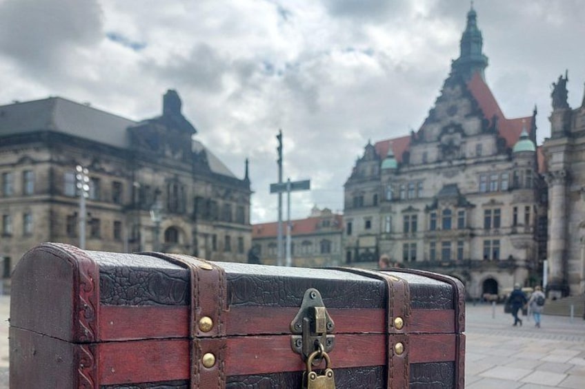 A vintage suitcase in the foreground with a historic building in the background. 2