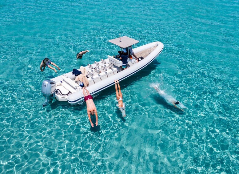 Una barca con persone che nuotano in acqua turchese cristallina. 1