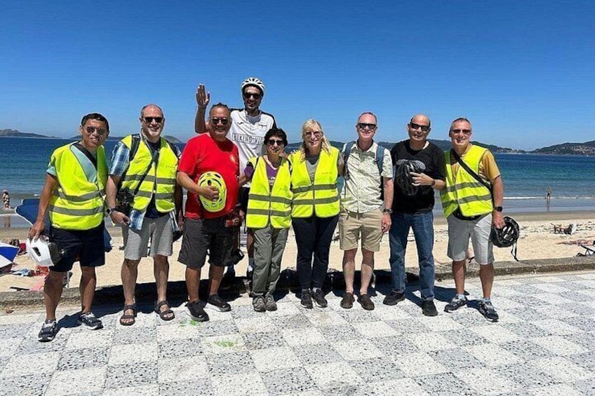 A group of people standing on a beach with a clear sky. 1