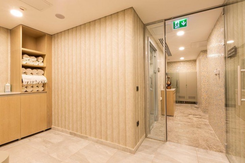 Une salle de bain moderne avec un meuble-lavabo en bois, un porte-serviettes et une cabine de douche en verre. 2