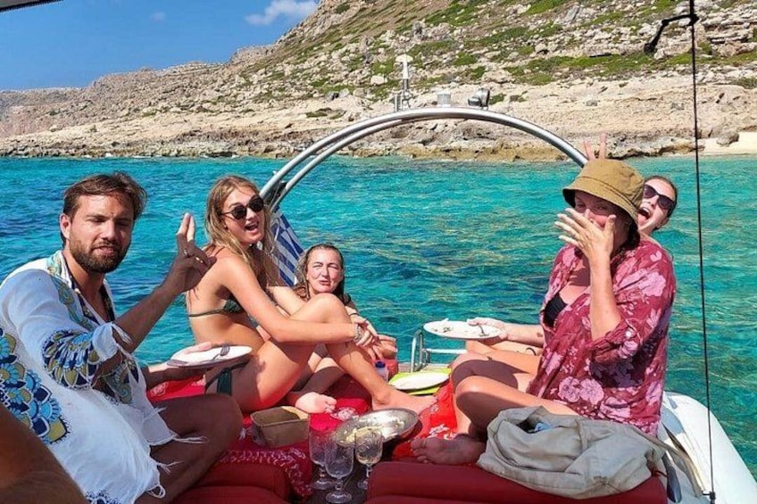 Un grupo de personas en un bote con un paisaje costero rocoso al fondo. 3