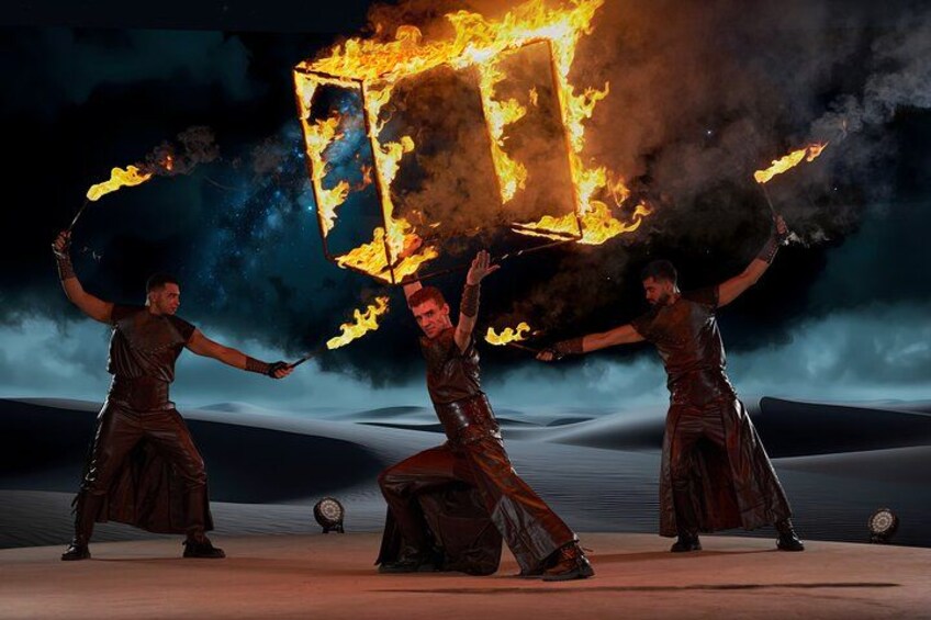 Three individuals performing with fire in a desert-like setting. 2