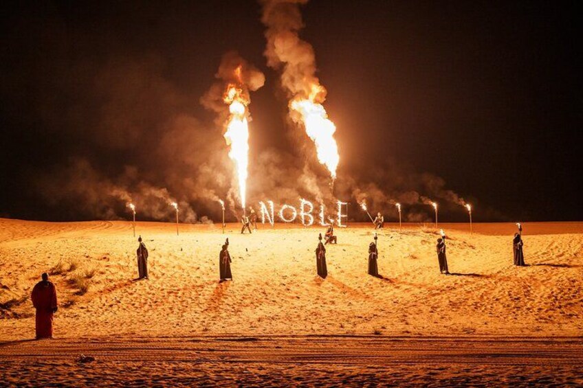 A desert scene with people holding torches, creating a fiery effect. 1