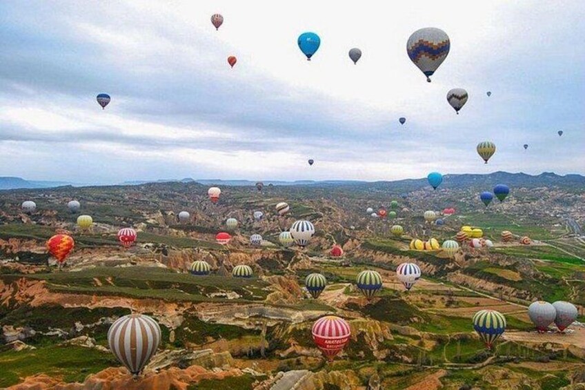 Paesaggio con numerosi palloni aerostatici di diversi colori e motivi. 5