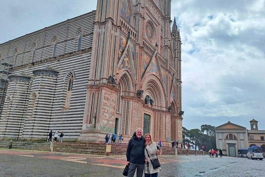 Una catedral grande con arquitectura detallada y un grupo de personas de pie frente a ella. 2