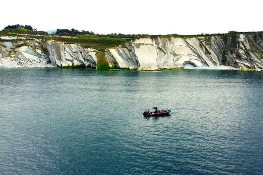 Un bateau sur une eau calme, avec des falaises en arrière-plan. 3
