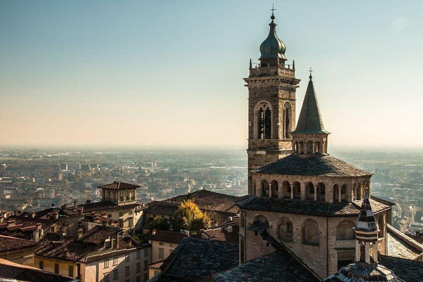 A historic church with a tall bell tower and a dome, surrounded by a cityscape. 3