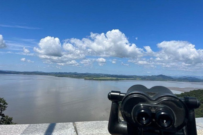 A body of water, a clear sky, and a distant landscape. 2