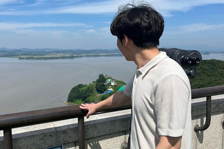 A person standing by a railing overlooking a river. 1