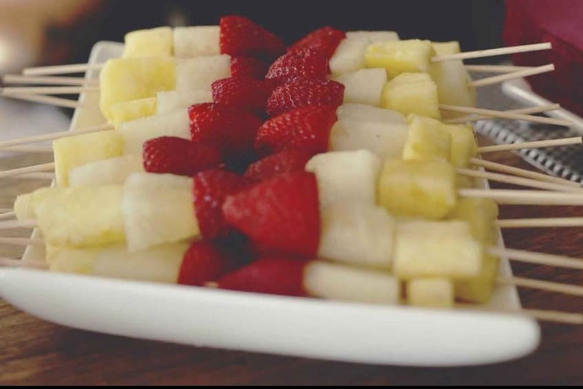 A plate of fruit skewers with bananas and strawberries. 4