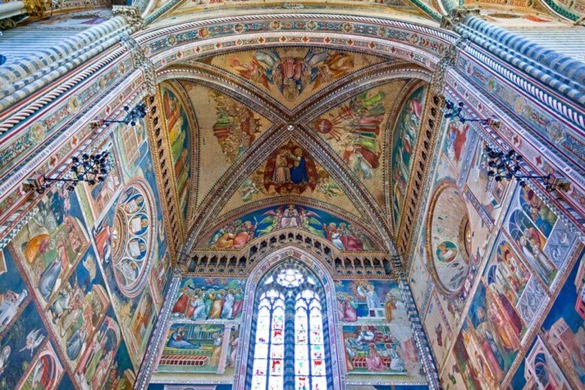 A detailed interior of a cathedral with a large stained glass window, intricate frescoes, and a vaulted ceiling. 5