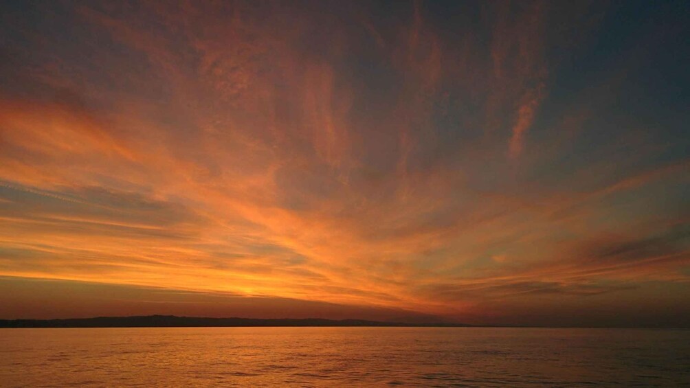 Atardecer sobre un cuerpo de agua con un cielo colorido. 4
