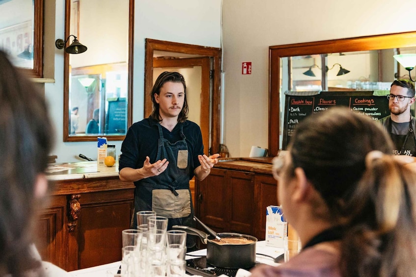A chef explaining a recipe to a group of diners at a restaurant. 5