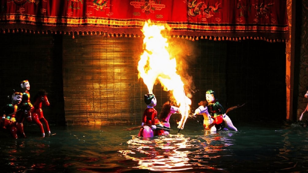 Artisti in costumi tradizionali con un grande fuoco al centro. 5