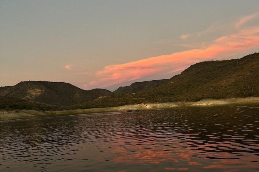 A calm river with reflections of the sky, surrounded by hills. 1
