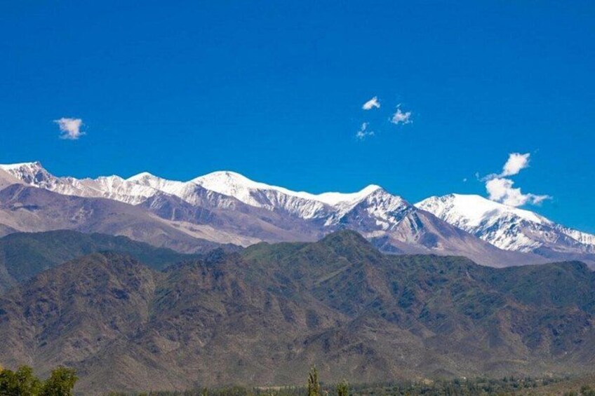 Une chaîne de montagnes dont les sommets enneigés se dressent sous un ciel bleu dégagé. 5