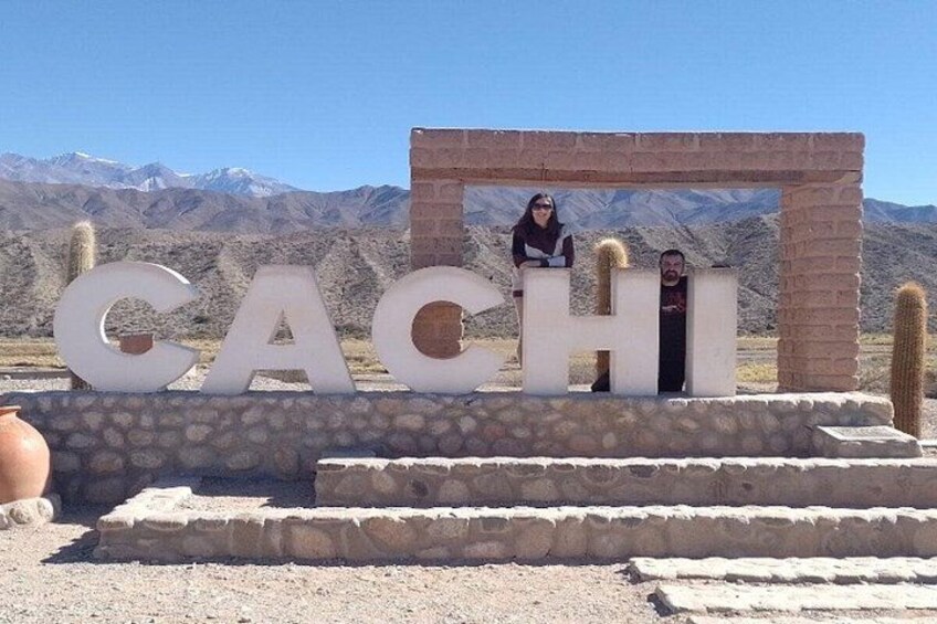 Une grande enseigne sur laquelle est écrit le mot « CACHI », et une personne se tient derrière. 3