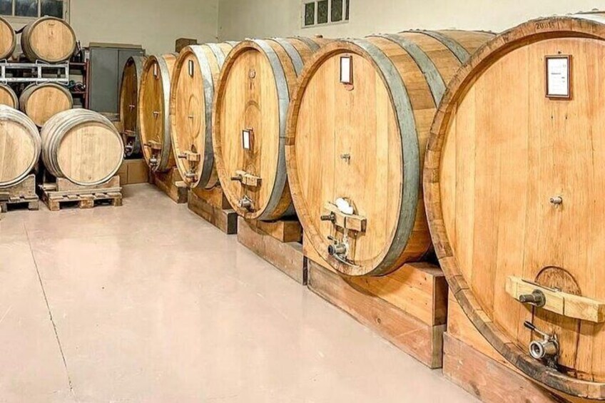 Wooden wine barrels lined up in a warehouse. 1