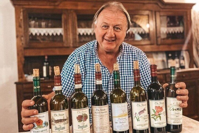 A person holding several wine bottles with labels. 1