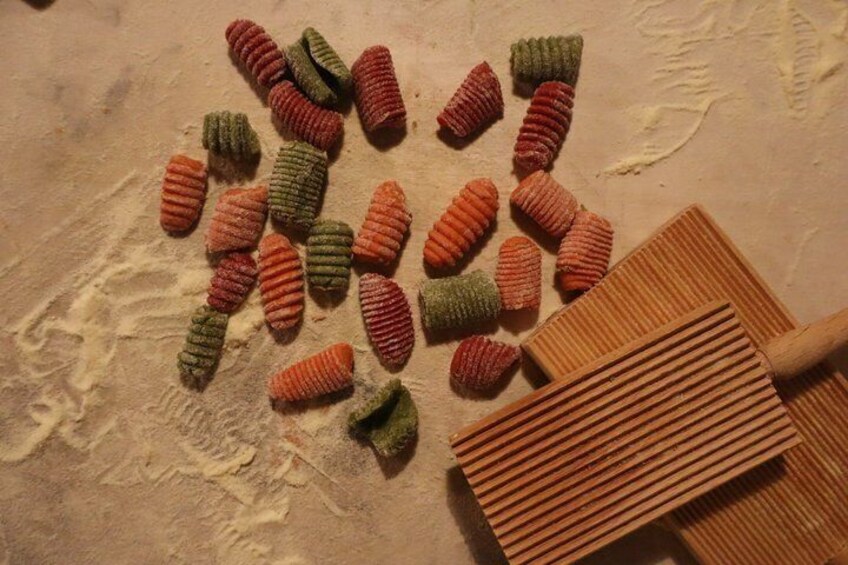 A collection of colorful, textured objects on a surface with a wooden tool. 3