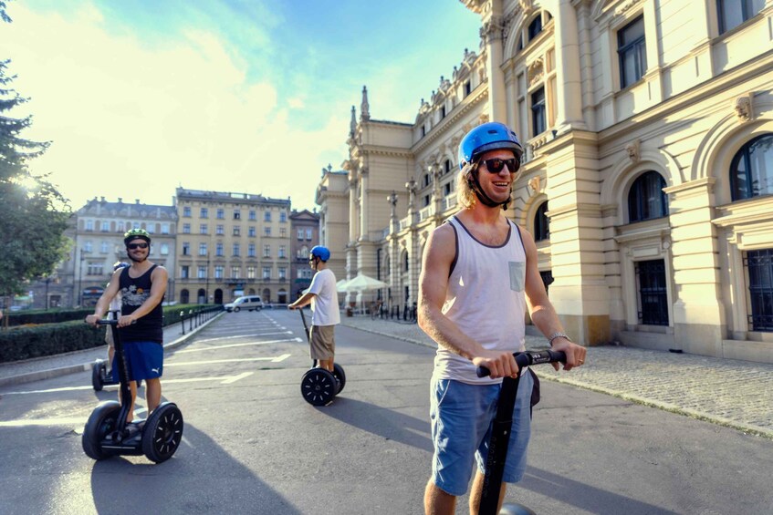 Three people riding segways on a city street with historic buildings in the background. 5