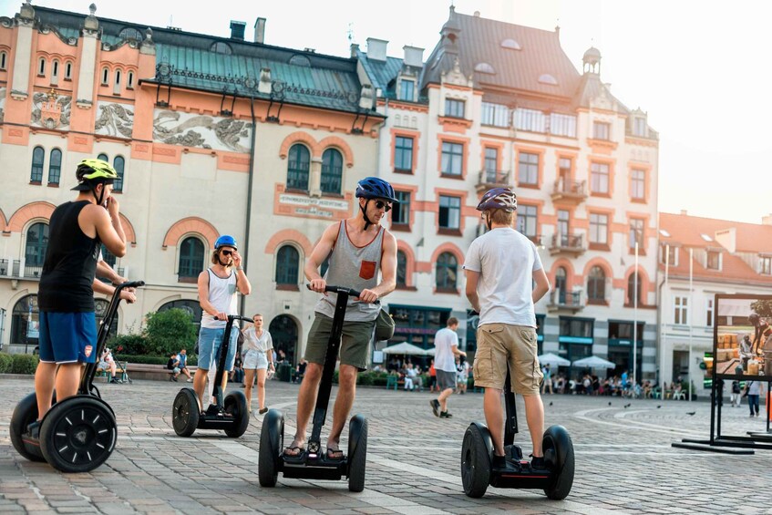 People riding Segways in a historic square with ornate buildings. 3