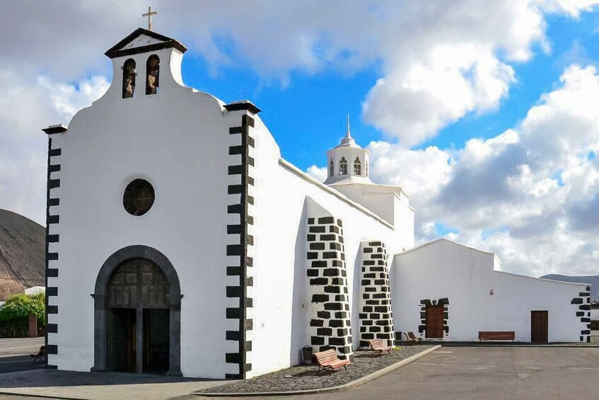 A white church with a bell tower and a smaller building with a cross on top. 3