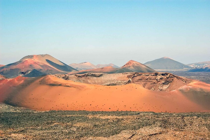 A desert landscape with rolling sand dunes and distant mountains under a clear sky. 1