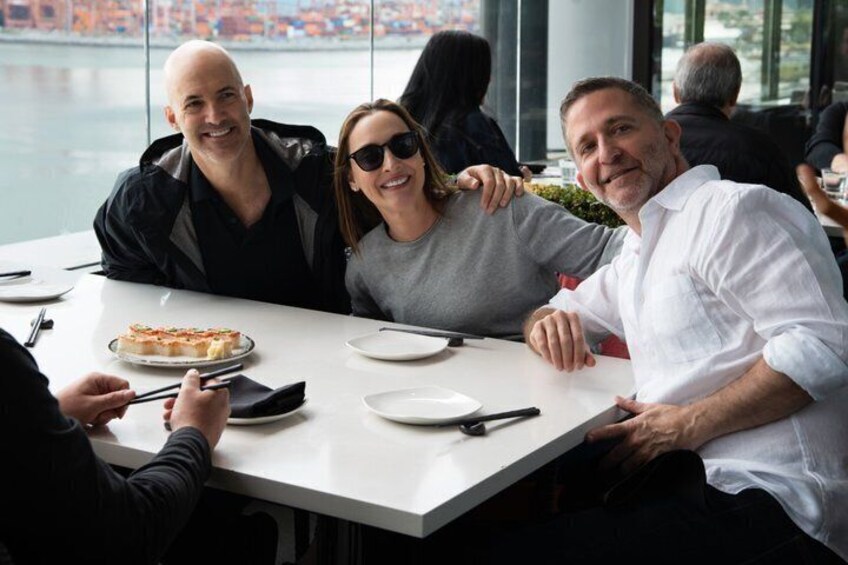 Tres personas cenando en una mesa con pizza y platos. 2