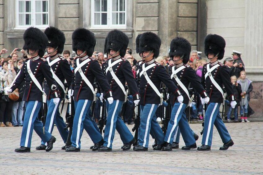 Eine Gruppe von Wachleuten in Uniform marschiert in Reih und Glied. 2