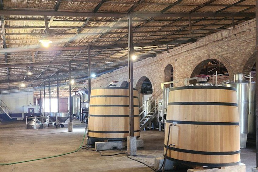 Een brouwerij interieur met houten vaten, bakstenen muren en metalen constructies. 4