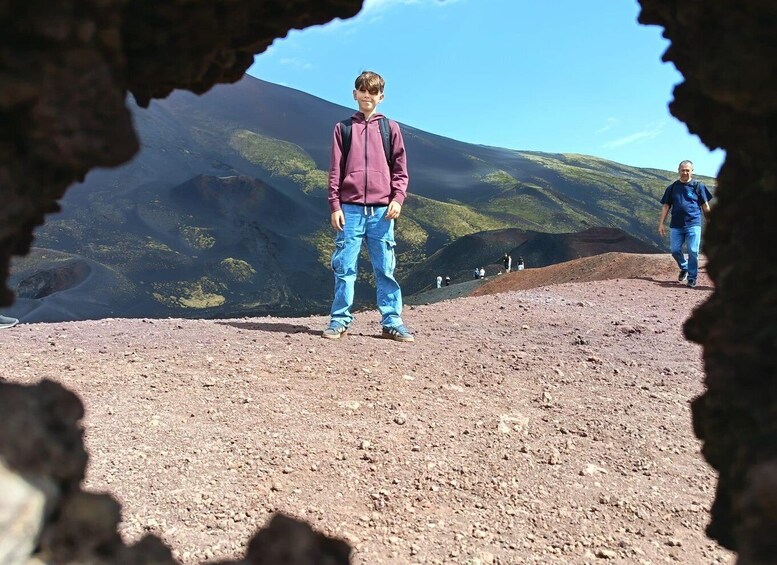 A person standing on a rocky terrain with a mountainous landscape in the background. 5