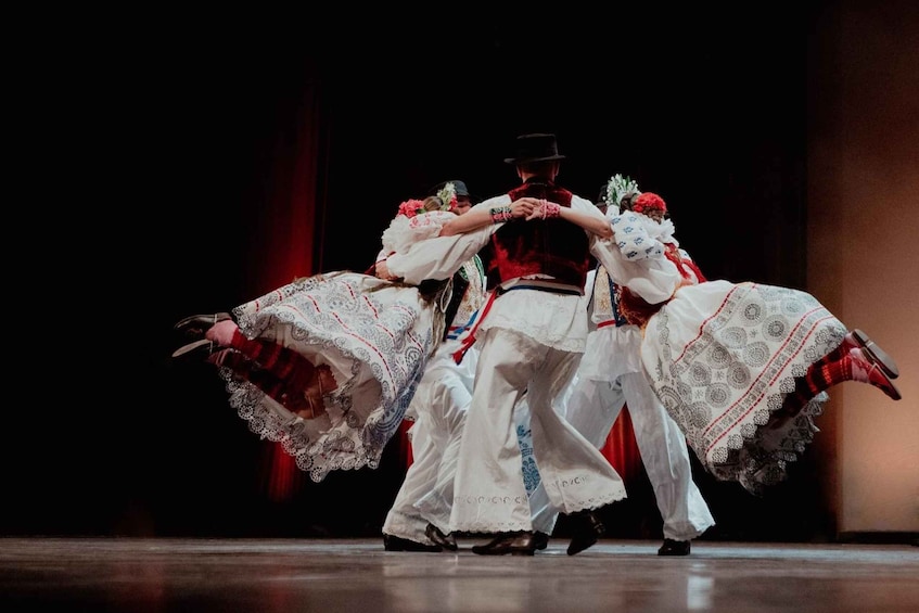 A dance performance with dancers in traditional white and red costumes. 3