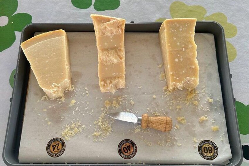 A baking tray with three pieces of cheese and a cheese grater. 2
